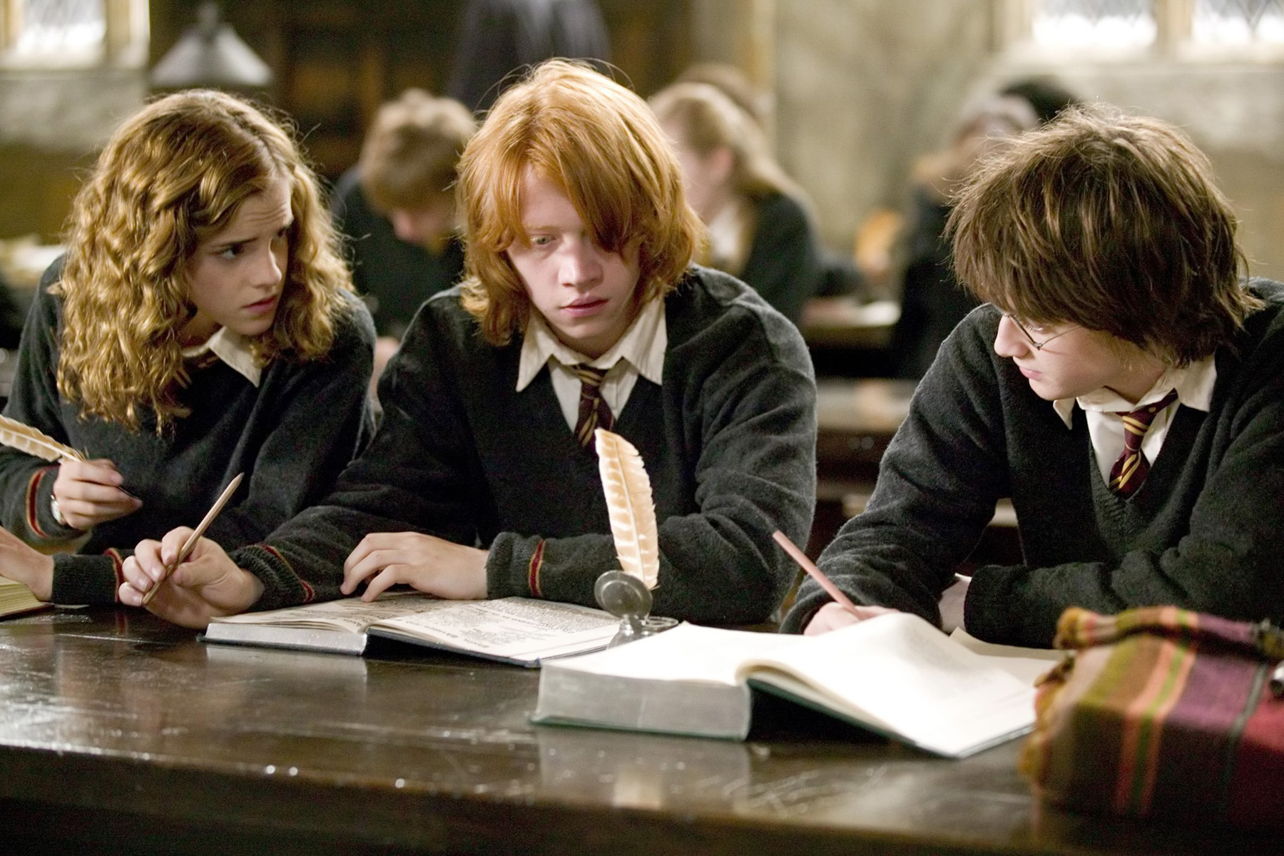 Hermione helps Ron and Harry with their homework